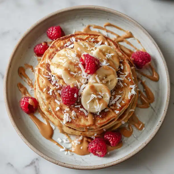 Banana Coconut Pancakes with Raspberries & Peanut Butter Drizzle