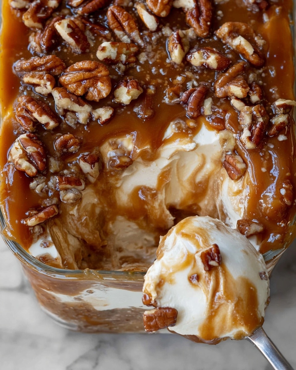A white rectangular dish holds a creamy dessert with three visible layers; the bottom layer is smooth and light beige, the middle layer is thick and covered in rich caramel brown sauce, topped with scattered chopped pecans in light and dark brown shades. A woman's hand holds a green apple slice dipped into the dessert, with some caramel and creamy layers sticking to the apple. The background is a white marbled surface. Photo taken with an iphone --ar 4:5 --v 7