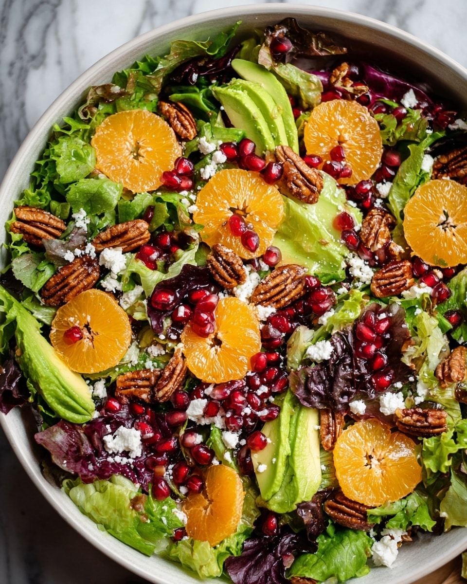 The salad is shown in a white bowl filled with several layers. The base layer is mixed green leaves with dark purple and light green colors and a soft, leafy texture. On top, there are bright orange mandarin slices, smooth avocado slices that are pale green, and deep red pomegranate seeds scattered evenly. There are also crunchy-looking candied pecans that have a brown color and rough texture. Crumbled small white cheese bits are sprinkled lightly over everything. The whole dish is presented on a white marbled surface, photo taken with an iphone --ar 4:5 --v 7