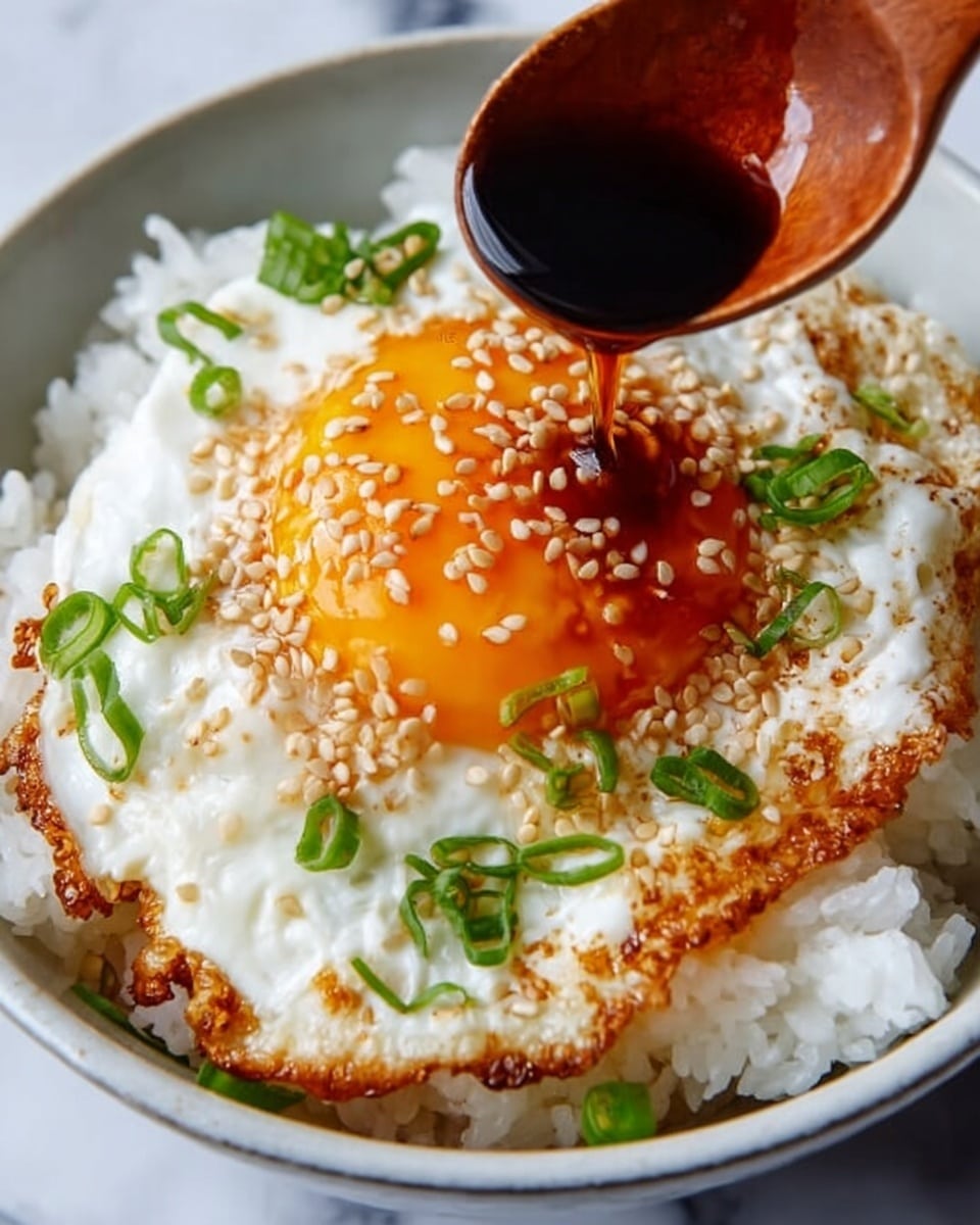 Large white serving bowl filled with a generous portion of steamed white rice topped with multiple sunny-side-up fried eggs featuring bright orange yolks, drizzled with glossy soy sauce and sprinkled with toasted sesame seeds and freshly chopped green onions, whole dish presented from a 3/4 angle on a white marble countertop with natural lighting, styled like a hero shot from a food magazine, photo taken with an iphone --ar 4:5 --v 7