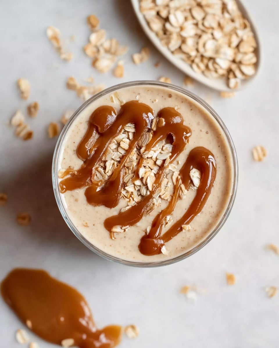A set of three tall white glasses filled with creamy peanut butter and oat smoothie, each topped generously with rolled oats and a drizzle of smooth peanut butter, arranged neatly on a white marble surface scattered with oats and accent pieces like whole dates and a golden spoon with peanut butter, shot at a 3/4 angle in natural light to capture the texture and inviting color, styled like a professional food magazine hero shot, photo taken with an iphone --ar 4:5 --v 7