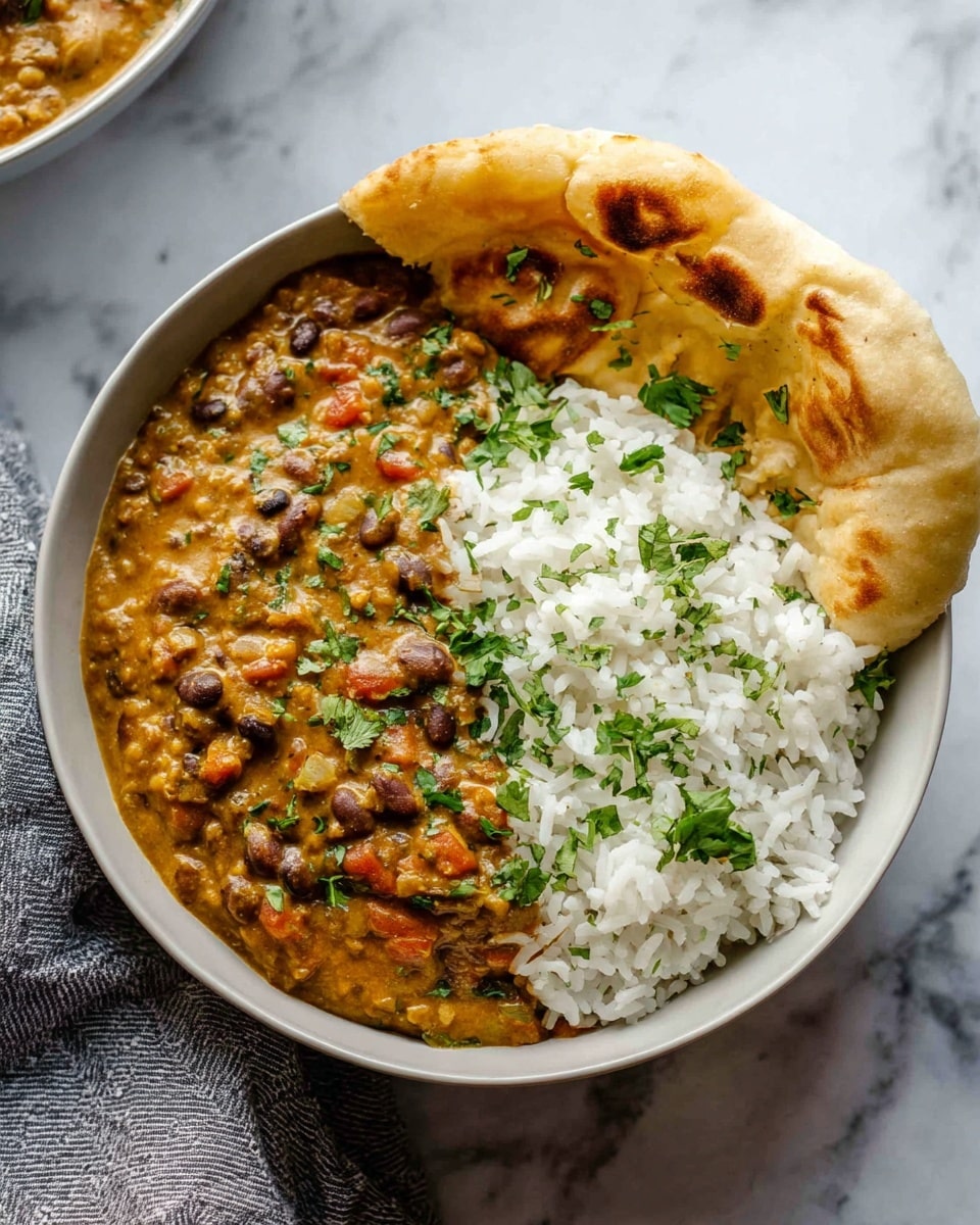 Large black cast iron skillet filled with creamy black bean curry, thickly simmered with chunks of tomatoes and garnished with fresh chopped cilantro, the whole dish presented on a white marble countertop with natural lighting, shot from a 3/4 angle, professional food magazine style photo taken with an iphone --ar 4:5 --v 7