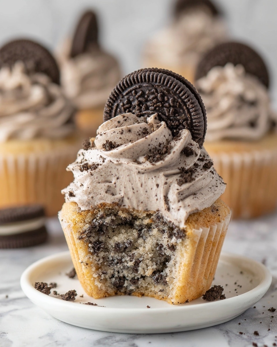 A white platter arranged with a complete dozen of cookies and cream cupcakes, each topped generously with swirled cookies and cream frosting and a whole Oreo cookie embedded on top, tiny Oreo crumbs sprinkled around for garnish, photographed from a 3/4 angle on a white marble surface, natural lighting highlighting the texture and swirl of the frosting, professional food styling photo taken with an iphone --ar 4:5 --v 7